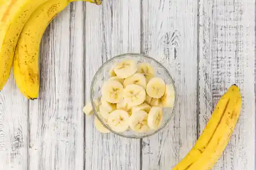 two banana and a bowl of cut banana=